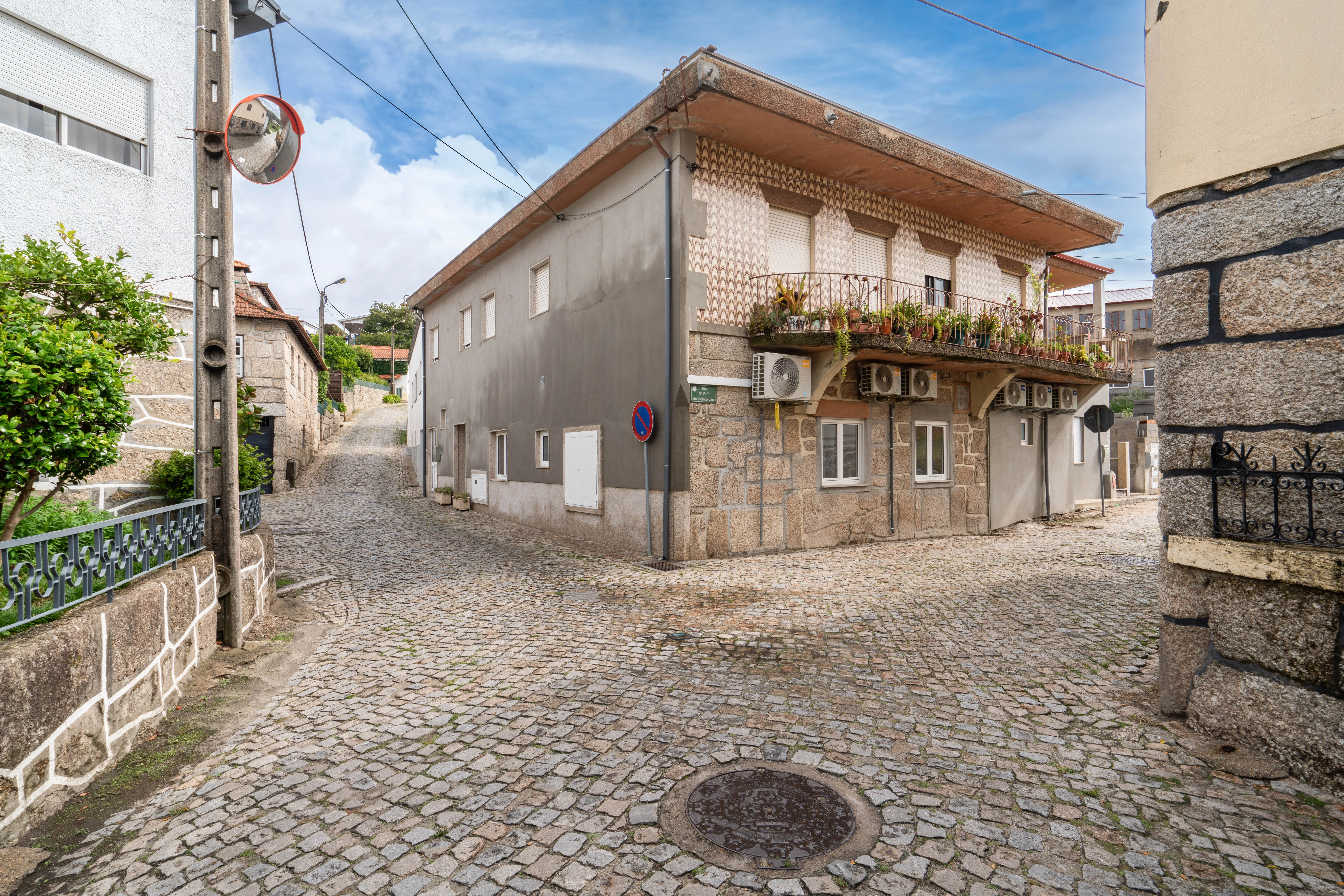 Casa da Petisqueira — Edifício na rua de calçada portuguesa em Paredes